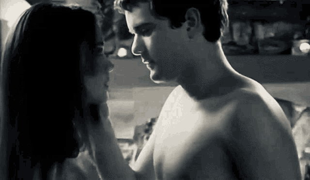 a black and white photo of a shirtless man and a woman