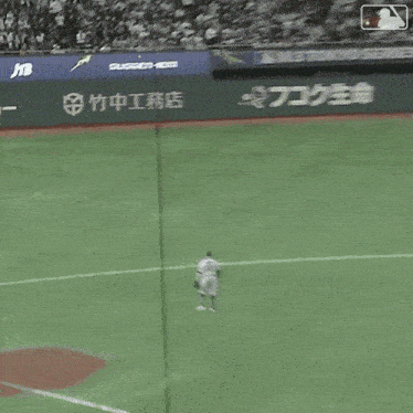 a baseball field with a jtb advertisement on the fence