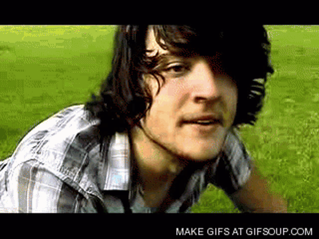 a man in a plaid shirt is looking at the camera with the words make gifs at gifsoup.com visible below him