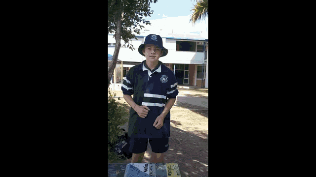 a young boy wearing a hat and a blue shirt with a badge on the front