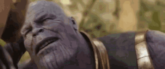 thanos from avengers infinity war is laying down with his eyes closed and a beard .