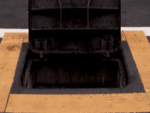 a manhole cover with a yellow stripe on the ground