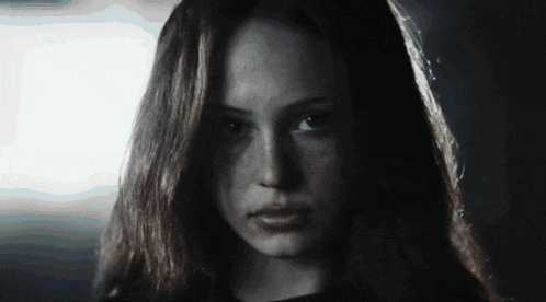 a close up of a woman 's face with long hair and freckles