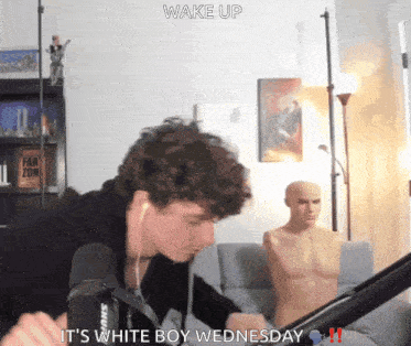 a man sitting in front of a microphone with the words wake up it 's white boy wednesday written above him
