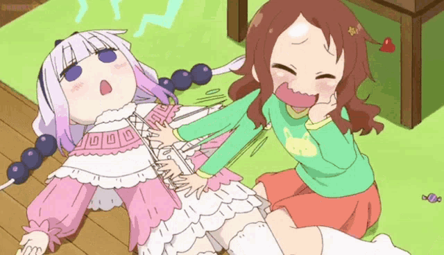 a girl in a green shirt is sitting next to a girl in a white dress