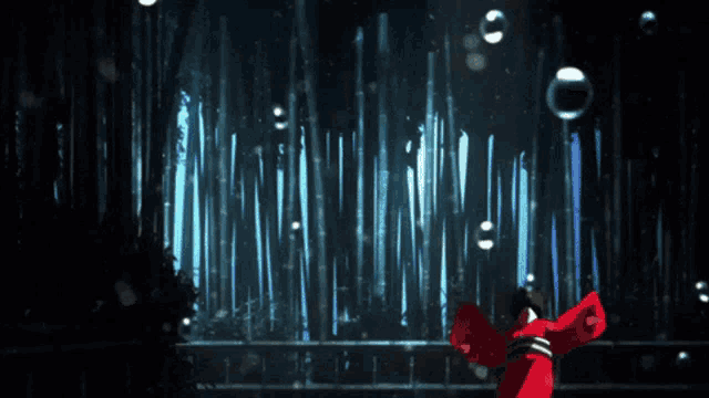 a woman in a red dress is dancing in front of a forest