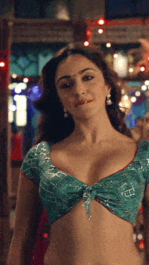 a woman in a green crop top is standing in a room