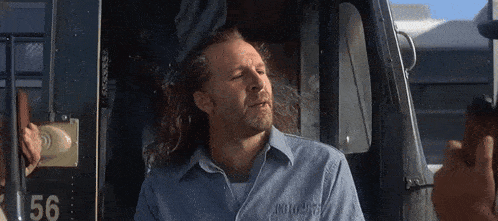 a man in a blue shirt has the number 56 on the door