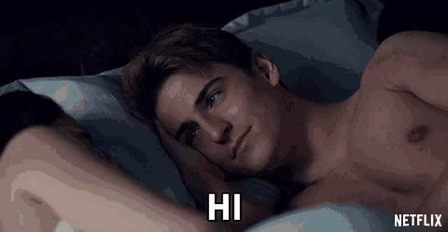 a shirtless man is laying on a bed with the words hi written on the bottom