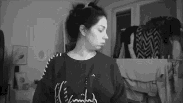a black and white photo of a woman wearing a sweater that says ' i 'm tired ' on it .
