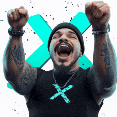 a man wearing a black shirt with an x on it is raising his arms in the air