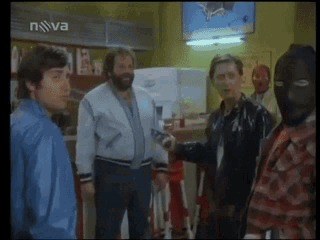 a group of men are standing in front of a tv screen that says nova on it