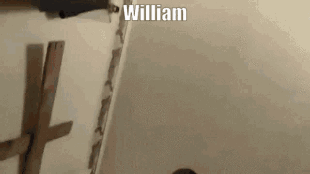 a person is standing next to a wall with the name william written on it .