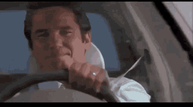 a man is sitting in the driver 's seat of a car .
