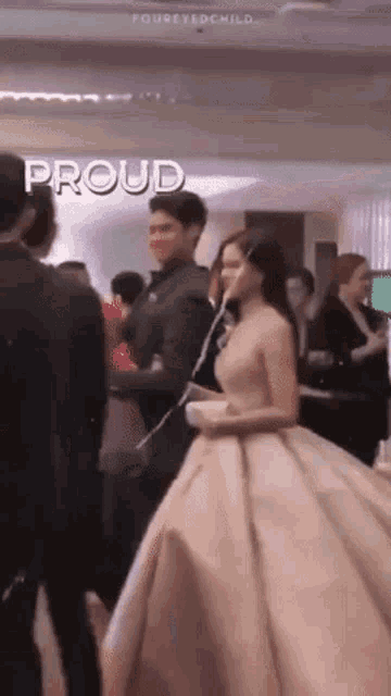 a woman in a pink dress is standing next to a man in a suit in a crowd .