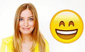a woman in a yellow shirt smiles next to a yellow smiley face