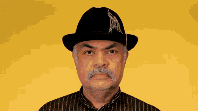 a man with a mustache is wearing a black hat and striped shirt