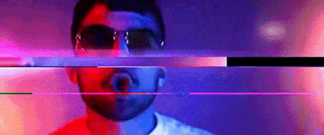 a man with a beard wearing sunglasses is surrounded by a rainbow of colors .