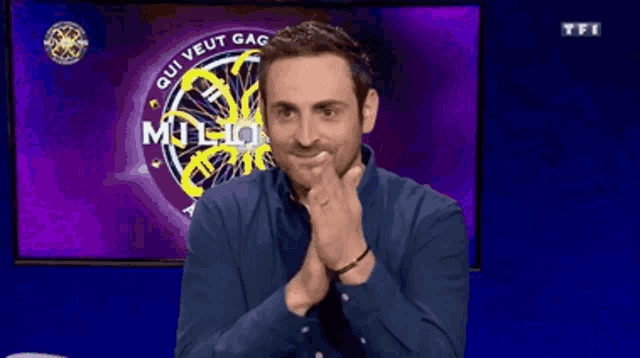 a man sitting in front of a screen that says qui veut gag million