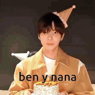 a man wearing a party hat is holding a cake with a candle .