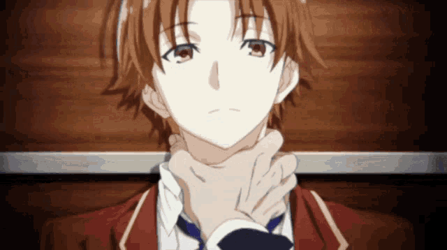 a man in a red jacket and tie has his hand on his chin