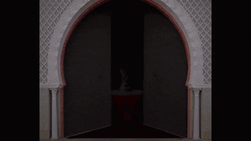 a door with a white arch and a red trim open