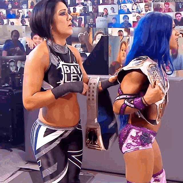 two female wrestlers are standing next to each other with one wearing a shirt that says bayley on it