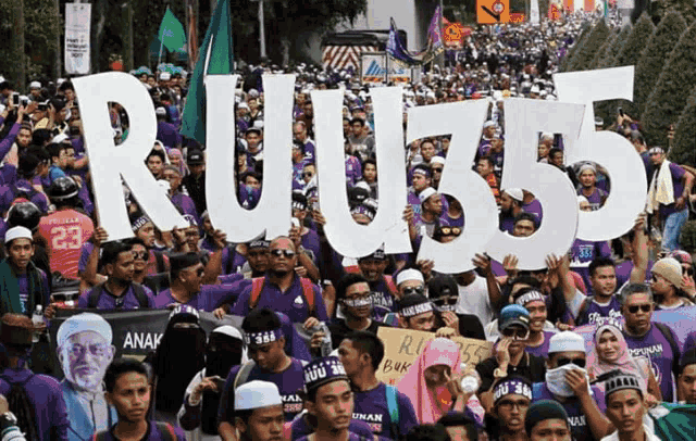 a large group of people are holding signs that say ruj55