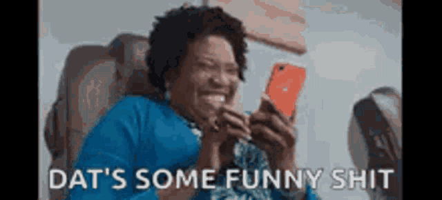 a woman is laughing while looking at her phone and the words dat 's some funny shit are above her .