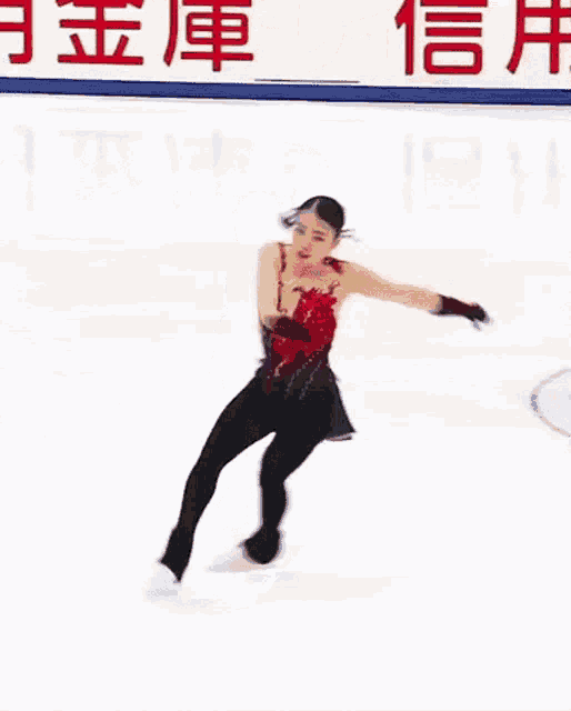 a woman is ice skating in front of a sign that says ' chinese ' on it