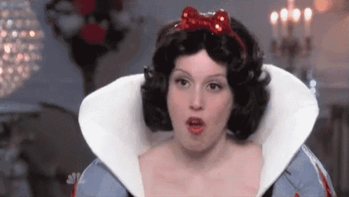 a woman in a snow white costume is making a face .