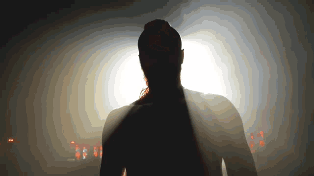 a silhouette of a person standing in the dark