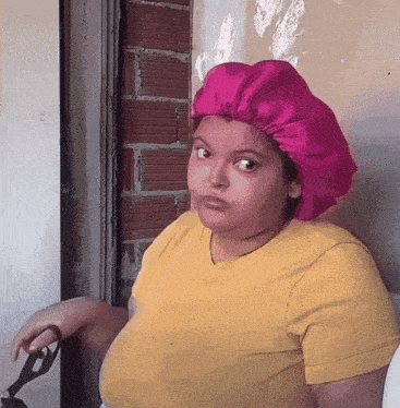 a woman wearing a pink hat is holding scissors
