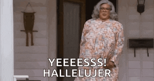 a man in a dress is standing in front of a door and saying yeeess ! hallelujar .