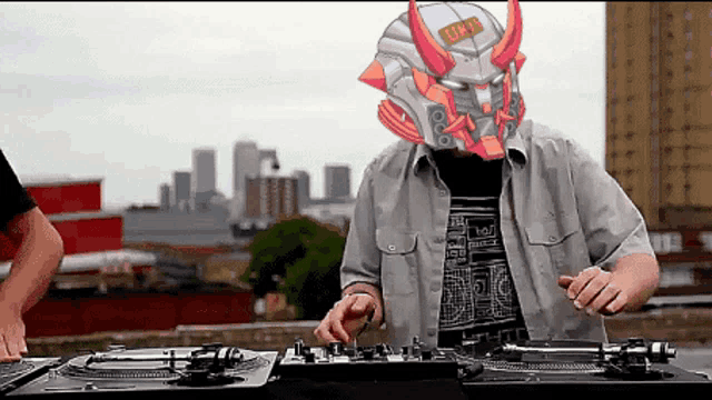 a man wearing a robot mask is playing music on a turntable