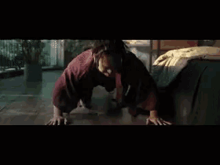 a woman in a red robe is doing push ups on the floor in front of a bed