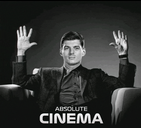 a man in a suit is sitting in a chair with his hands in the air and the words absolute cinema below him