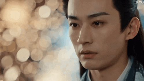 a close up of a young man 's face with a blurry background