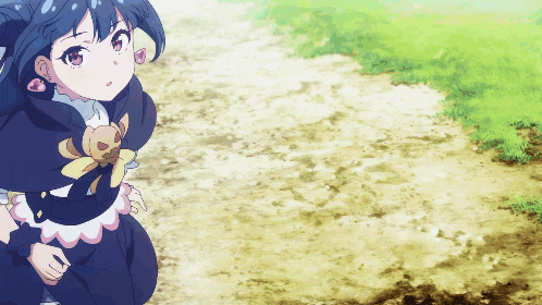 a girl with a teddy bear on her chest is standing on a dirt road
