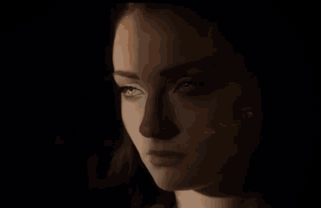 a close up of a woman 's face in the dark