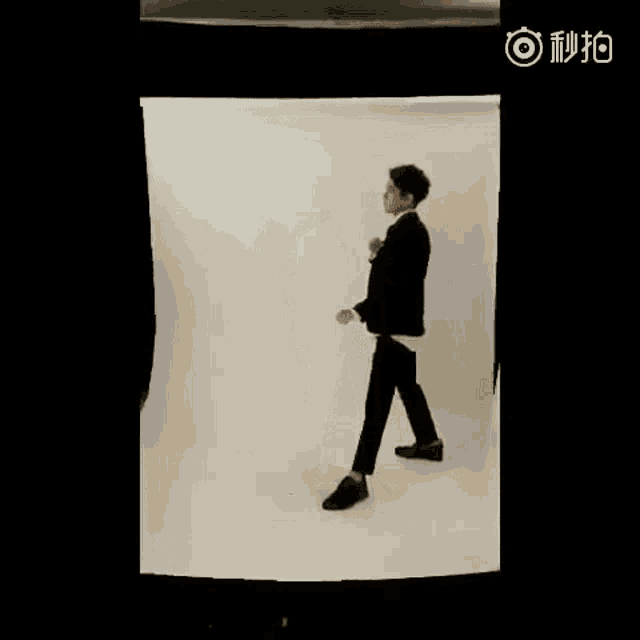 a man in a suit is dancing in front of a camera .