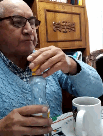 a man with glasses is drinking from a plastic bottle