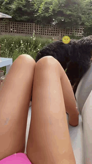 a woman in a pink bikini is laying on a couch with her legs crossed