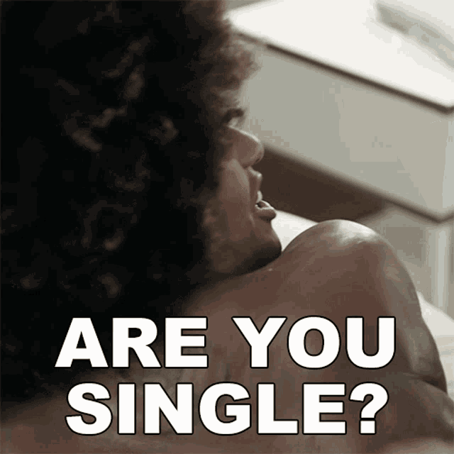 a man with curly hair is laying on a bed with the words " are you single " above him