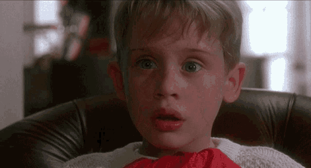 a young boy is sitting in a chair with his mouth open