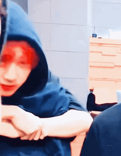 a man with red hair wearing a blue hoodie