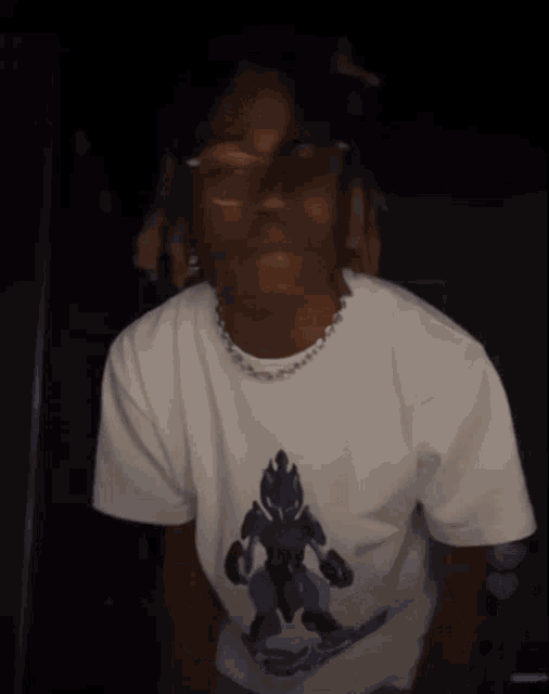 a man wearing glasses and a white t-shirt is giving the middle finger