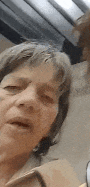 a close up of a woman 's face with her eyes closed and a blurred background .