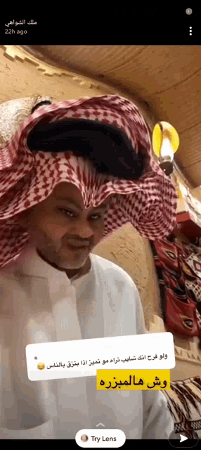 a man wearing a checkered head scarf and a white shirt has a try lens sticker next to him