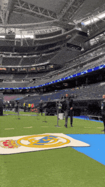 an empty stadium with a blue carpet and a white banner with the real madrid logo